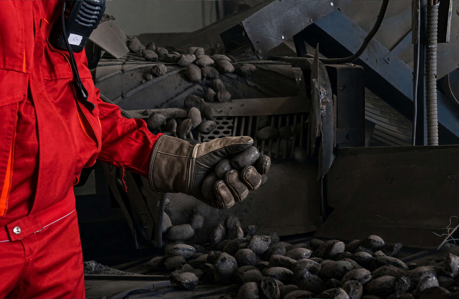 Worker holding a briquette beside the production line