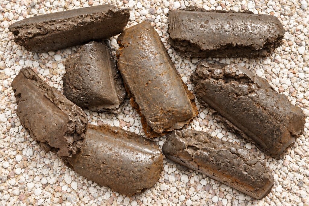 Hot briquetted iron (HBI) briquettes on a gravel surface